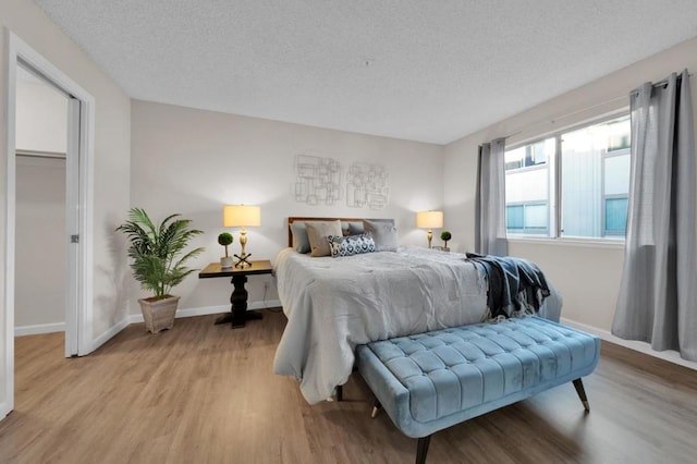 bedroom featuring a textured ceiling and light wood-type flooring