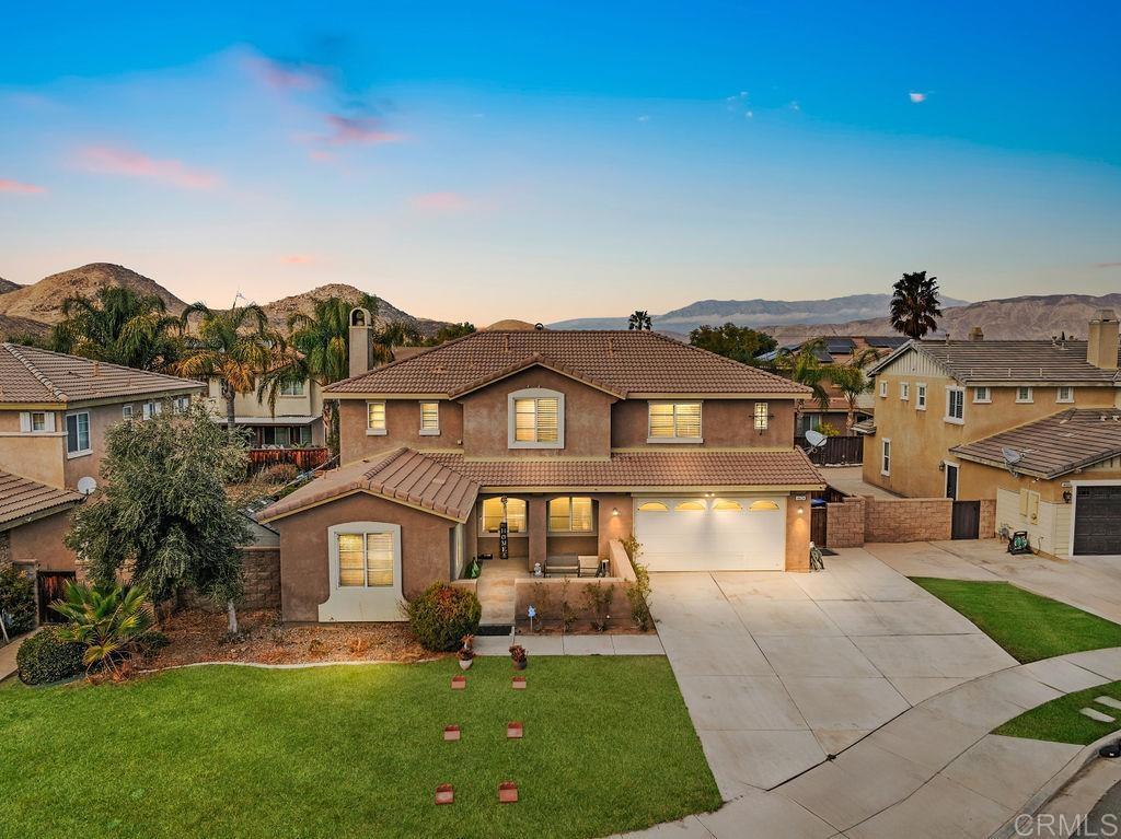 view of front of house featuring a mountain view, a garage, and a yard