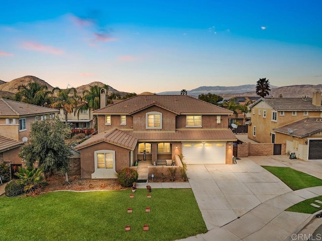 view of front of house featuring a mountain view, a garage, and a yard