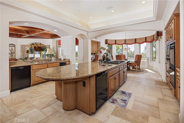 6 Inspiration, Laguna Niguel, CA 92677 - kitchen with black appliances, light stone counters, an island with sink, ornamental molding, and brown cabinets
