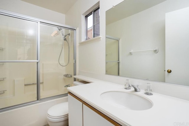 full bathroom featuring bath / shower combo with glass door, vanity, and toilet