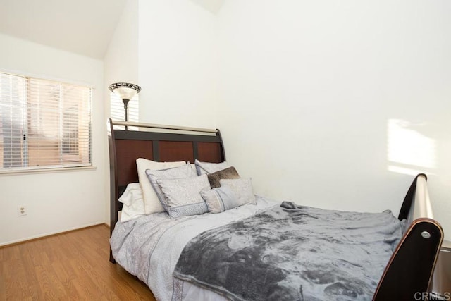 bedroom featuring light hardwood / wood-style flooring and vaulted ceiling