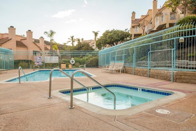 view of swimming pool featuring a hot tub and a patio