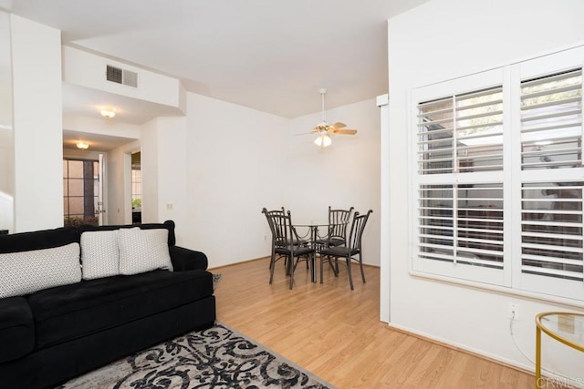 living room featuring ceiling fan and light hardwood / wood-style floors