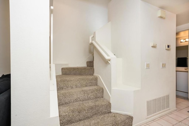 staircase featuring tile patterned flooring