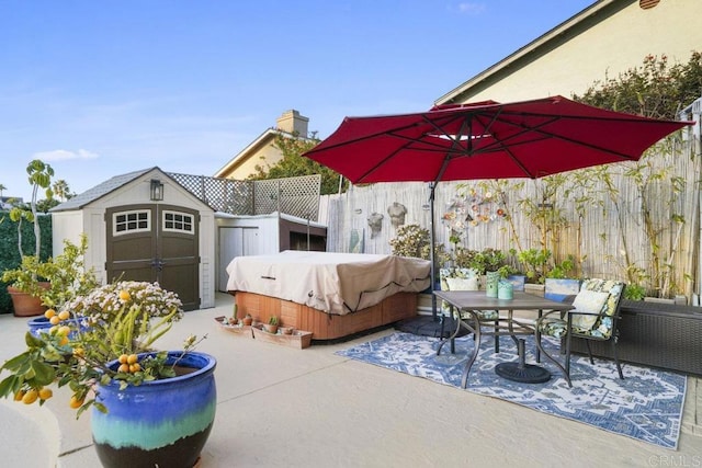 view of patio / terrace with a grill, a hot tub, and a shed