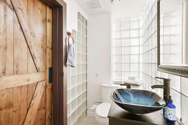 bathroom featuring tile patterned flooring, vanity, and toilet