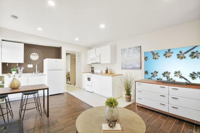 kitchen with white cabinetry and white appliances