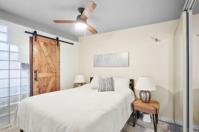 bedroom with a barn door and ceiling fan