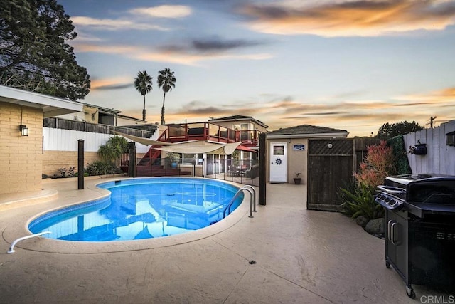 pool at dusk featuring a patio area