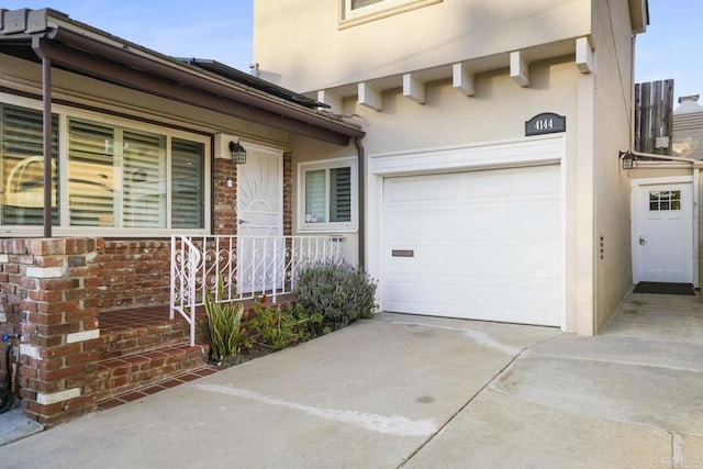 view of exterior entry featuring a porch and a garage