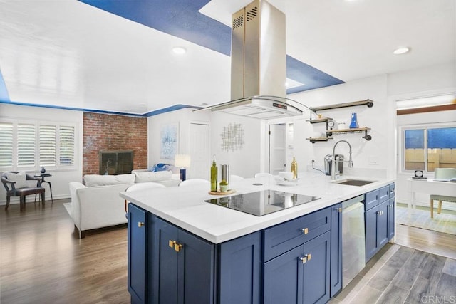 kitchen with island range hood, blue cabinets, sink, black electric stovetop, and stainless steel dishwasher