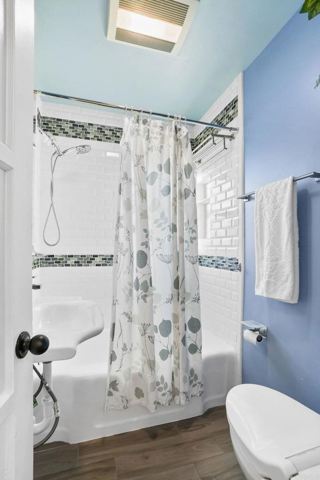 bathroom featuring toilet and shower / bath combo with shower curtain