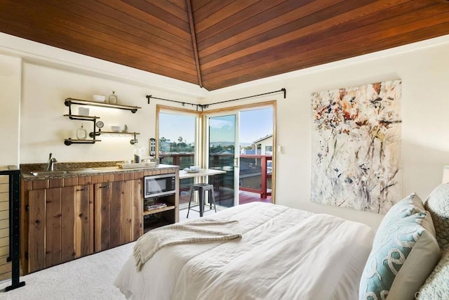 bedroom with carpet flooring, access to exterior, and indoor wet bar