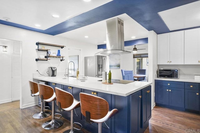 kitchen featuring white cabinetry, black appliances, a breakfast bar, and island exhaust hood