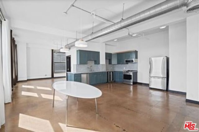 kitchen featuring blue cabinetry, appliances with stainless steel finishes, sink, and tasteful backsplash