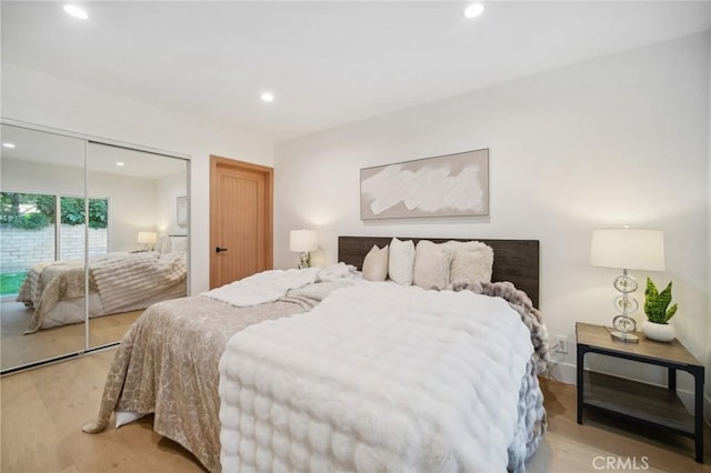 bedroom with light hardwood / wood-style flooring and a closet