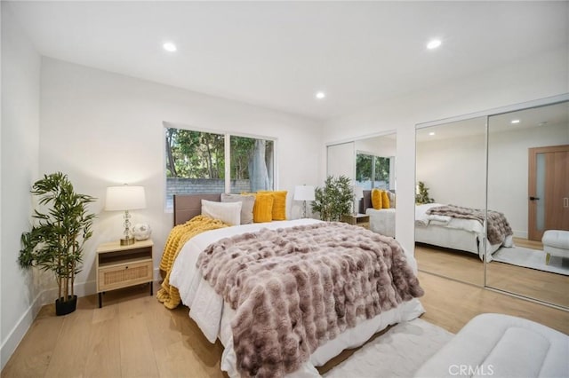 bedroom featuring two closets and light wood-type flooring