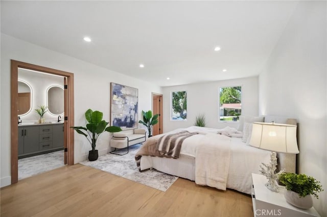 bedroom featuring hardwood / wood-style flooring and connected bathroom