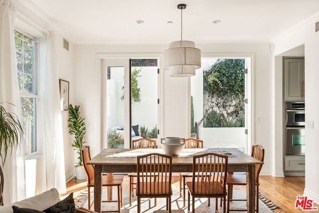 dining space featuring light hardwood / wood-style flooring and ornamental molding