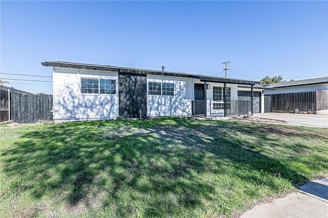 ranch-style house featuring covered porch and a front lawn