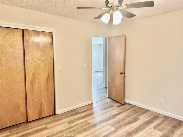 unfurnished bedroom with a closet, ceiling fan, a textured ceiling, and light hardwood / wood-style flooring