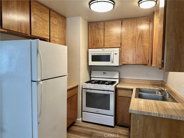 kitchen featuring white appliances, dark hardwood / wood-style flooring, and sink