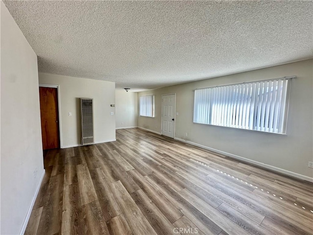 spare room featuring hardwood / wood-style floors and a textured ceiling