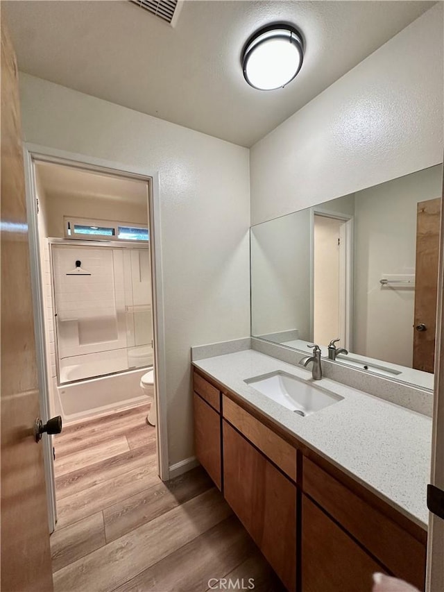 full bathroom with shower / tub combination, wood-type flooring, toilet, and vanity