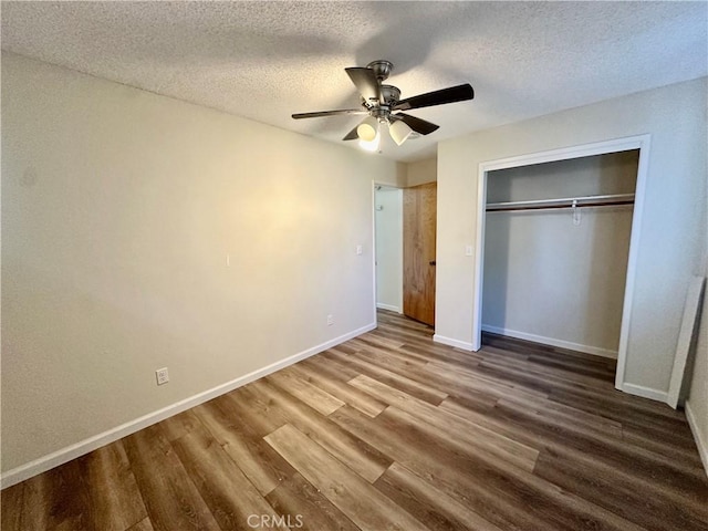 unfurnished bedroom featuring ceiling fan, wood-type flooring, a closet, and a textured ceiling