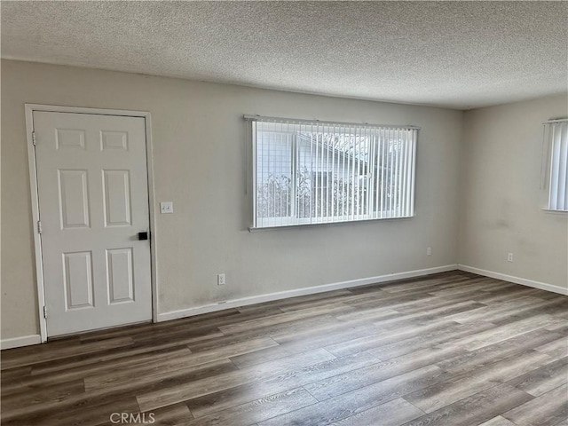 empty room with hardwood / wood-style flooring and a textured ceiling