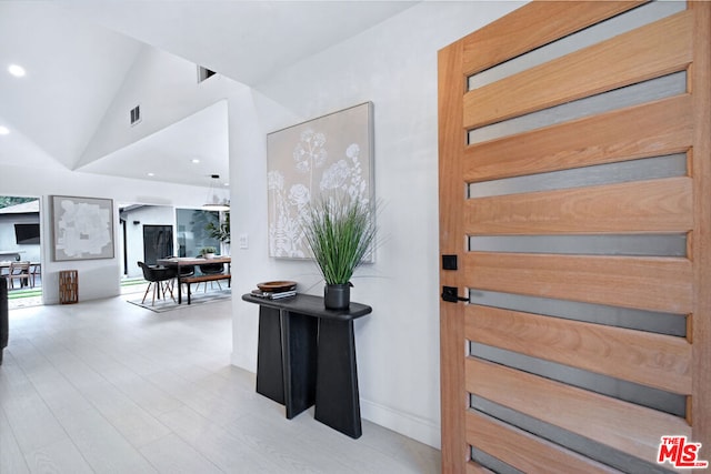 foyer entrance featuring lofted ceiling and light hardwood / wood-style flooring