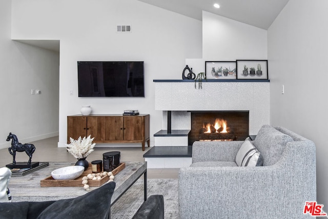 living room featuring lofted ceiling and a fireplace