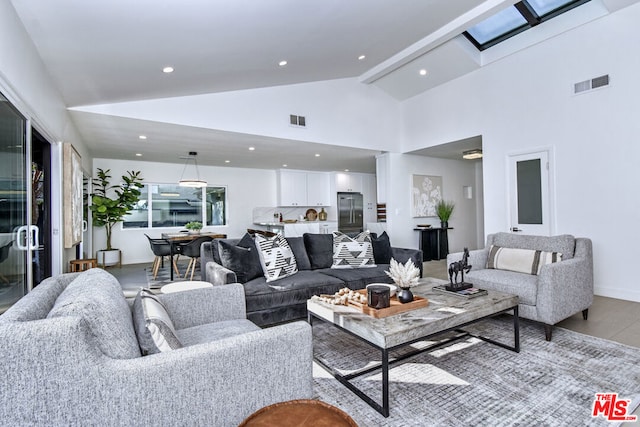 living room with beamed ceiling, high vaulted ceiling, and light wood-type flooring