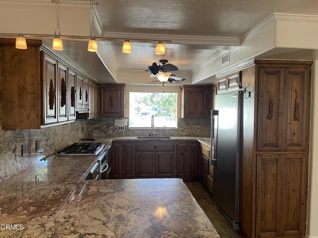 kitchen featuring pendant lighting, sink, decorative backsplash, ornamental molding, and stainless steel appliances