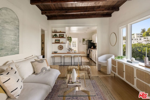 living room with beam ceiling, wood ceiling, and dark hardwood / wood-style floors