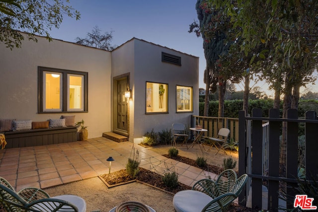 back house at dusk with a patio