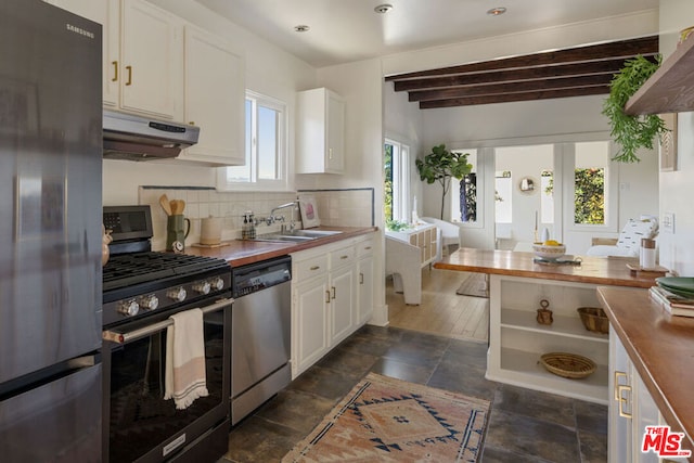 kitchen with wood counters, appliances with stainless steel finishes, and white cabinets