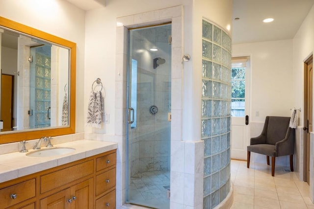 bathroom featuring tile patterned flooring, vanity, and a shower with door