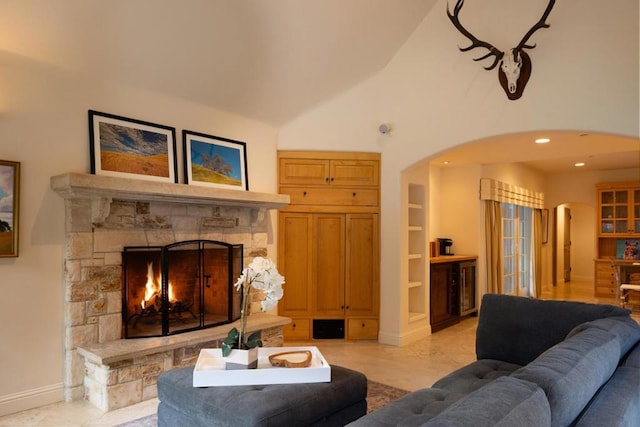 living room featuring vaulted ceiling, built in features, and a fireplace