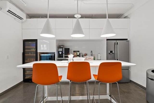 kitchen featuring white cabinetry, a breakfast bar, a wall mounted AC, and a kitchen island with sink