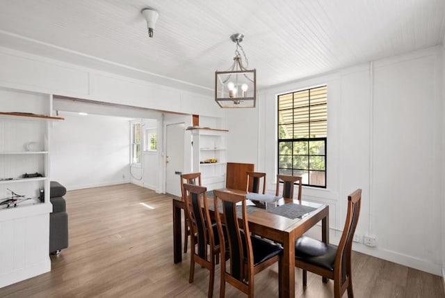 dining area with a notable chandelier and light hardwood / wood-style floors