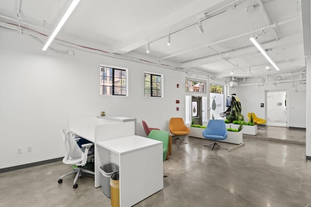 office area with concrete flooring and rail lighting