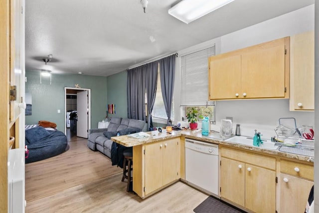 kitchen with sink, white dishwasher, light hardwood / wood-style floors, kitchen peninsula, and light brown cabinets