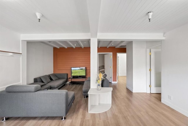 living room with beamed ceiling and light hardwood / wood-style floors