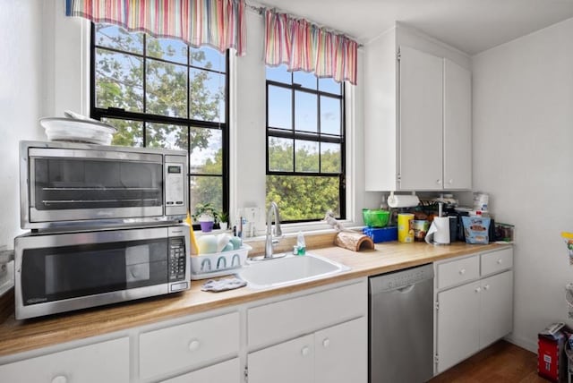 kitchen featuring dark wood-type flooring, stainless steel appliances, sink, and white cabinets