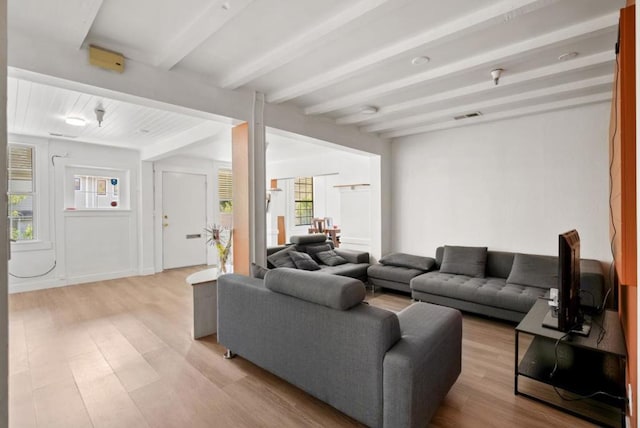 living room featuring beamed ceiling and light wood-type flooring