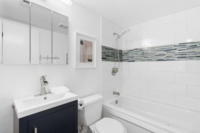 full bathroom featuring vanity, tiled shower / bath, and toilet