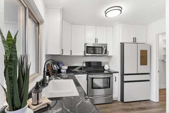 kitchen with stainless steel appliances, white cabinetry, and sink