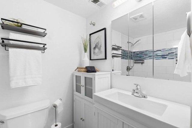 bathroom featuring sink, toilet, and tiled shower